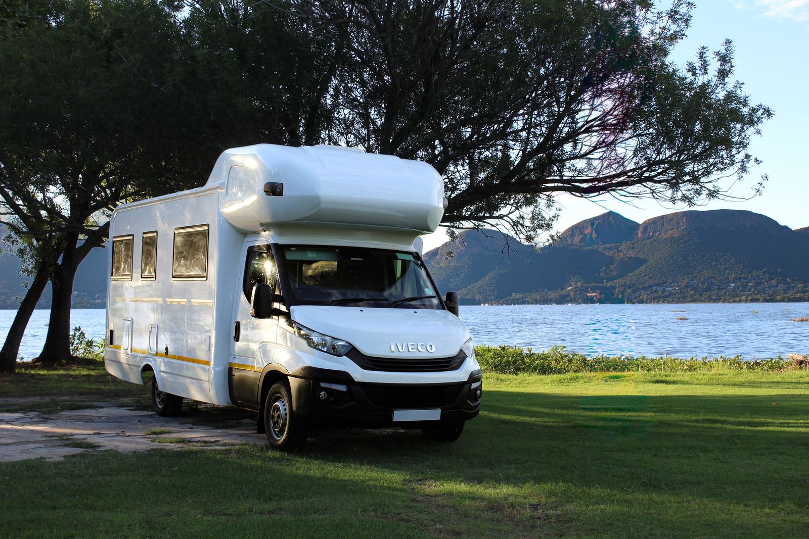 Wohnmobil am See vor Bergkulisse